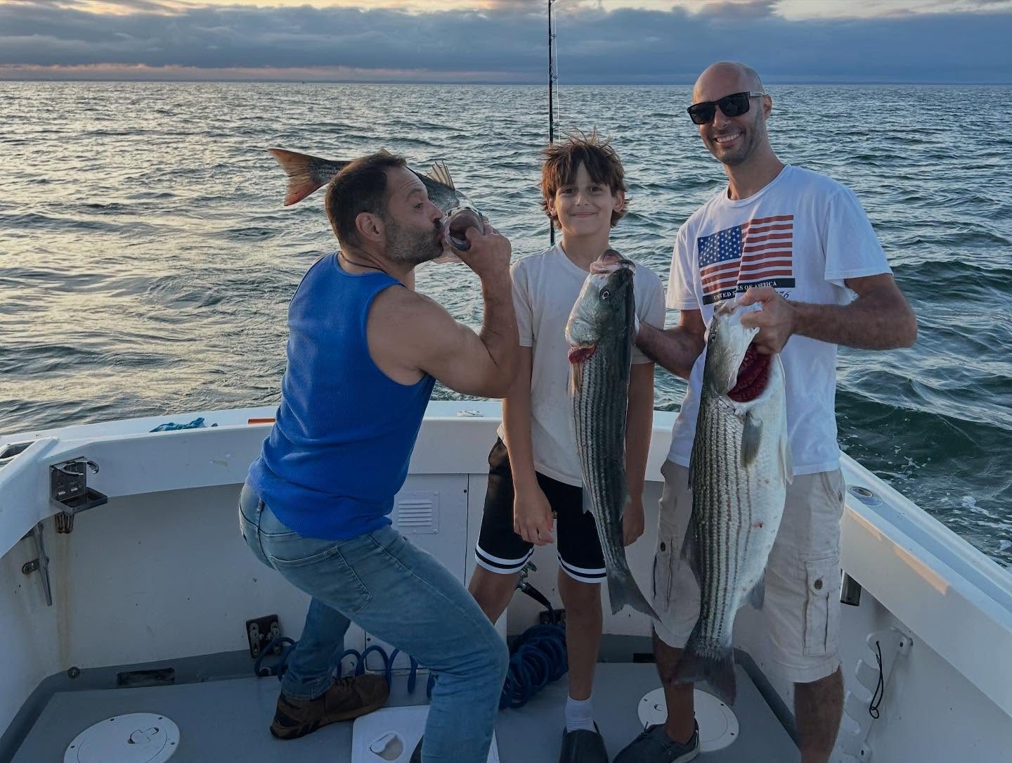 Two anglers with bluefish and striped bass on a Long Island Sound fishing charter