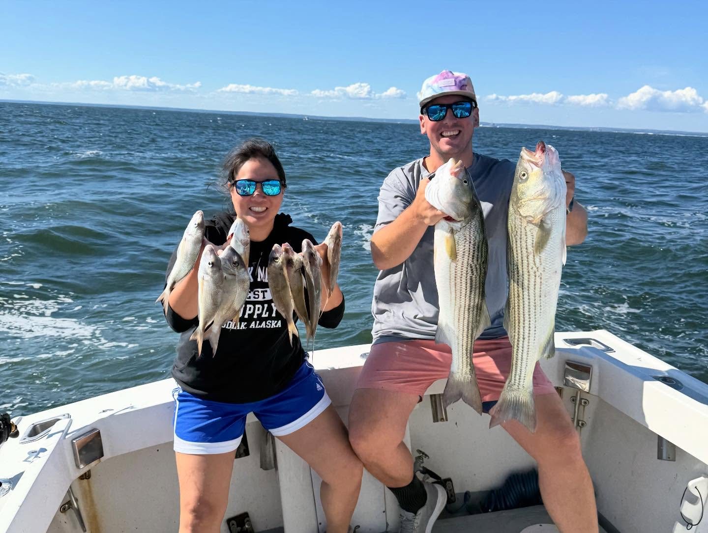 Group of anglers holding up striped bass on a private charter out of Mount Sinai