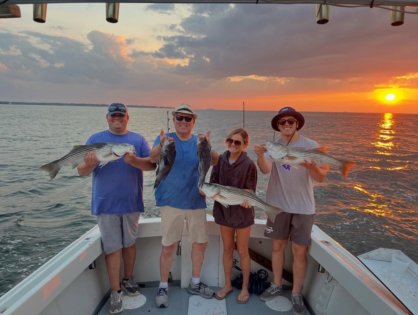 Anglers with their catch against a vivid Long Island Sound sunset
