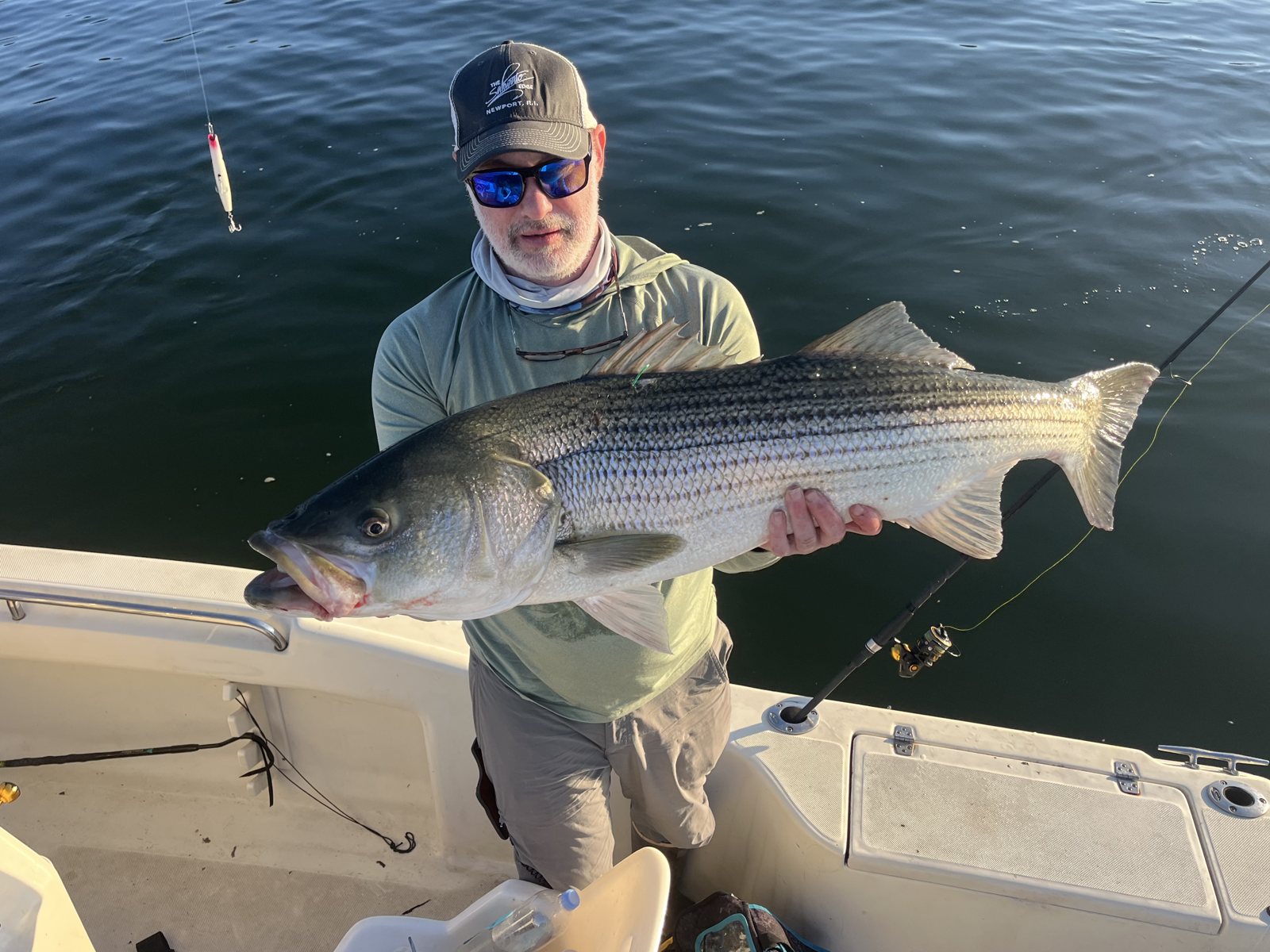 Angler holding a striped bass caught off Mount Sinai, NY
