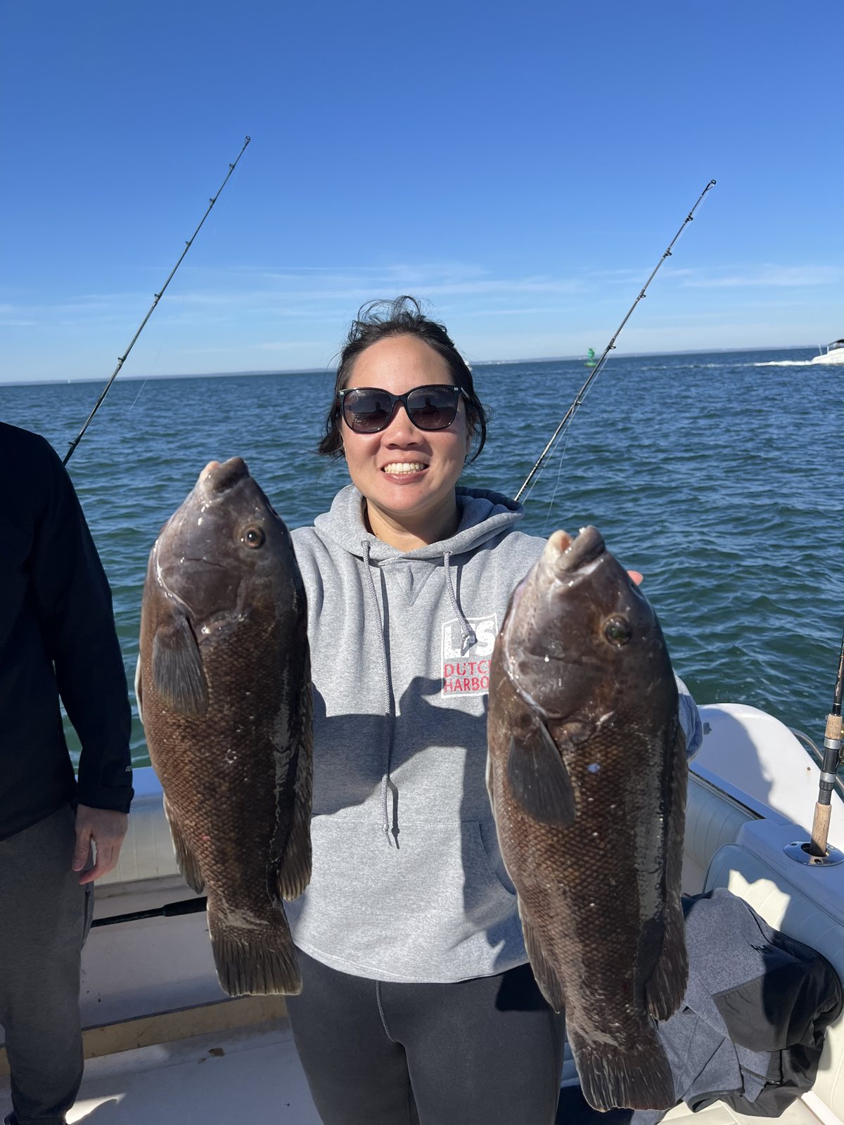 Angler holding two blackfish caught on a fall charter off Mount Sinai
